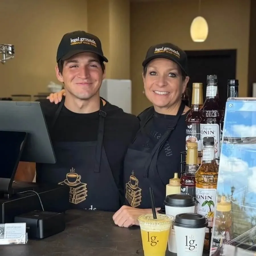 Shon Cook and Samuel Stevens standing behind the counter of Legal Grounds coffee shop.